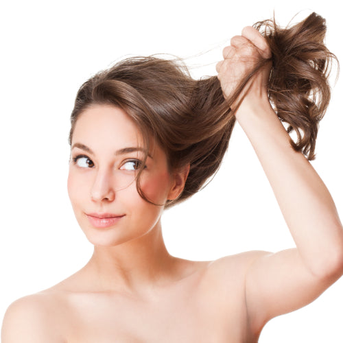 Girl smiling whilst lifting her healthy, shiny hair