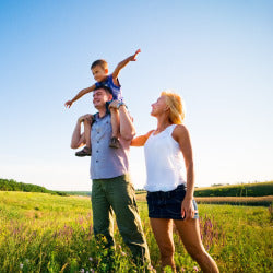 Young boy on man shoulders with woman watching and smiling