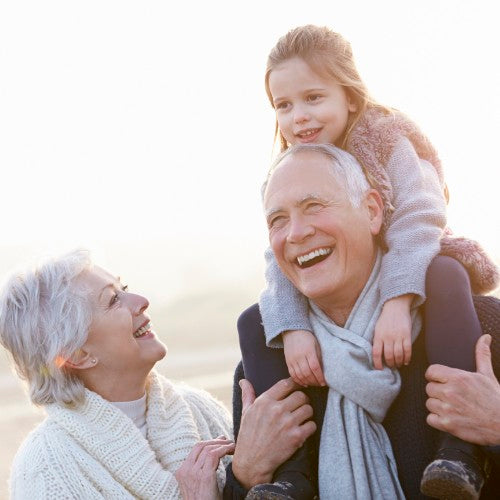 Older man and woman with younger girl smiling