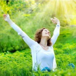 Woman stretching in a field in the sun
