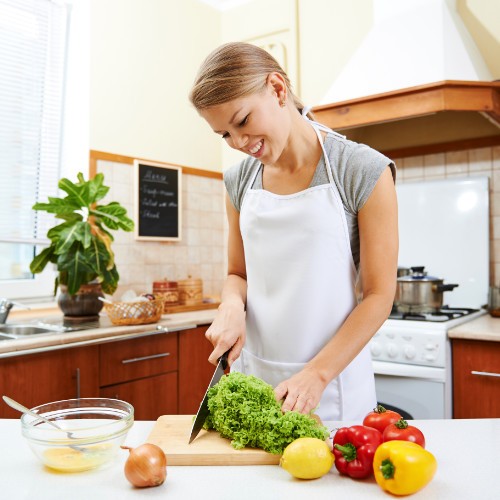 Woman chopping fruit and vegetables in the kitchen