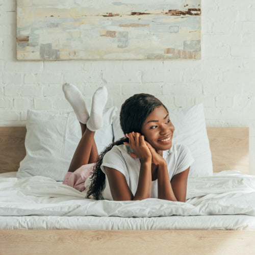 Woman laid on bed smiling