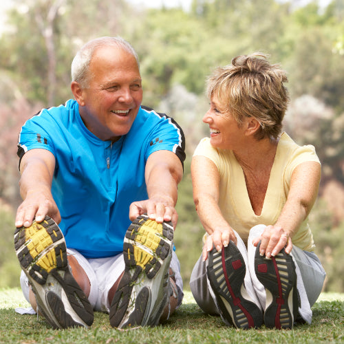 Man and woman exercising touching toes and smiling
