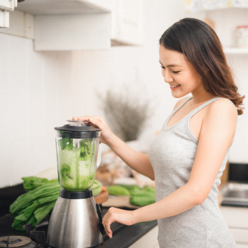Woman making a smoothie from healthy food