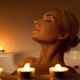 Woman relaxing a bath with candles