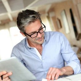Man with glasses working reading papers