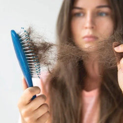 Woman pulling hair form a brush not very happy