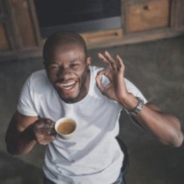 Man laughing, drinking tea and doing the OK sign
