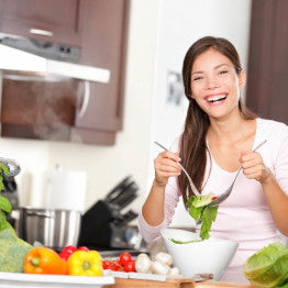 Woman tossing a salad in the kitchen