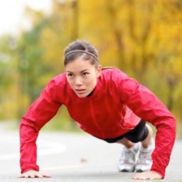 Woman in red top doing press ups